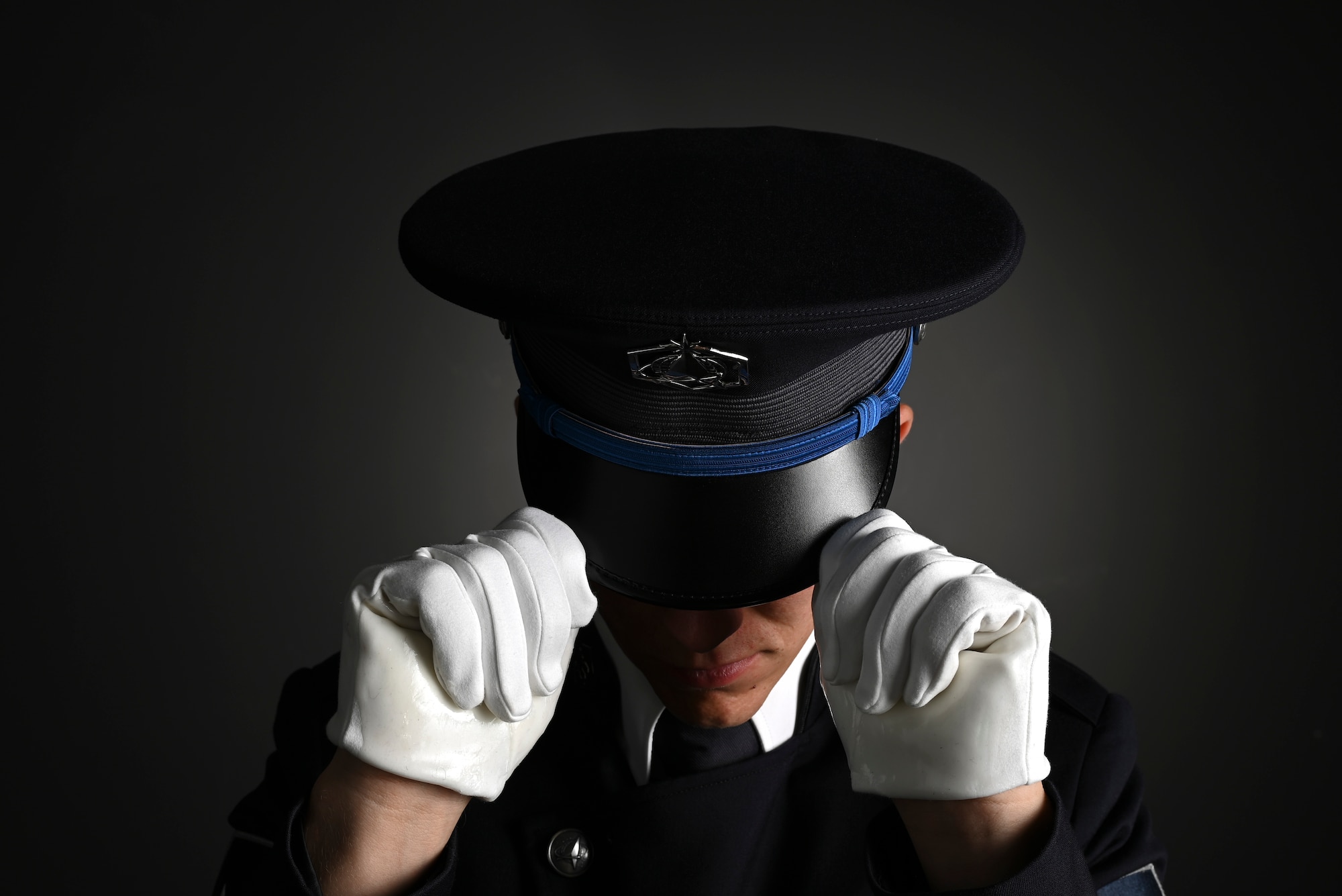 U.S. Space Force Spc. 3 Dylan Lee, ceremonial guardsman with the U.S. Space Force Honor Guard, dons the new Honor Guard ceremonial cap at Joint Base Anacostia-Bolling, Washington, D.C., Aug. 21, 2026. The updated uniform features a distinct Space Force blue belt, cap, and rope over the left shoulder. (U.S. Air Force Photo by Senior Airman Shanel Toussaint)