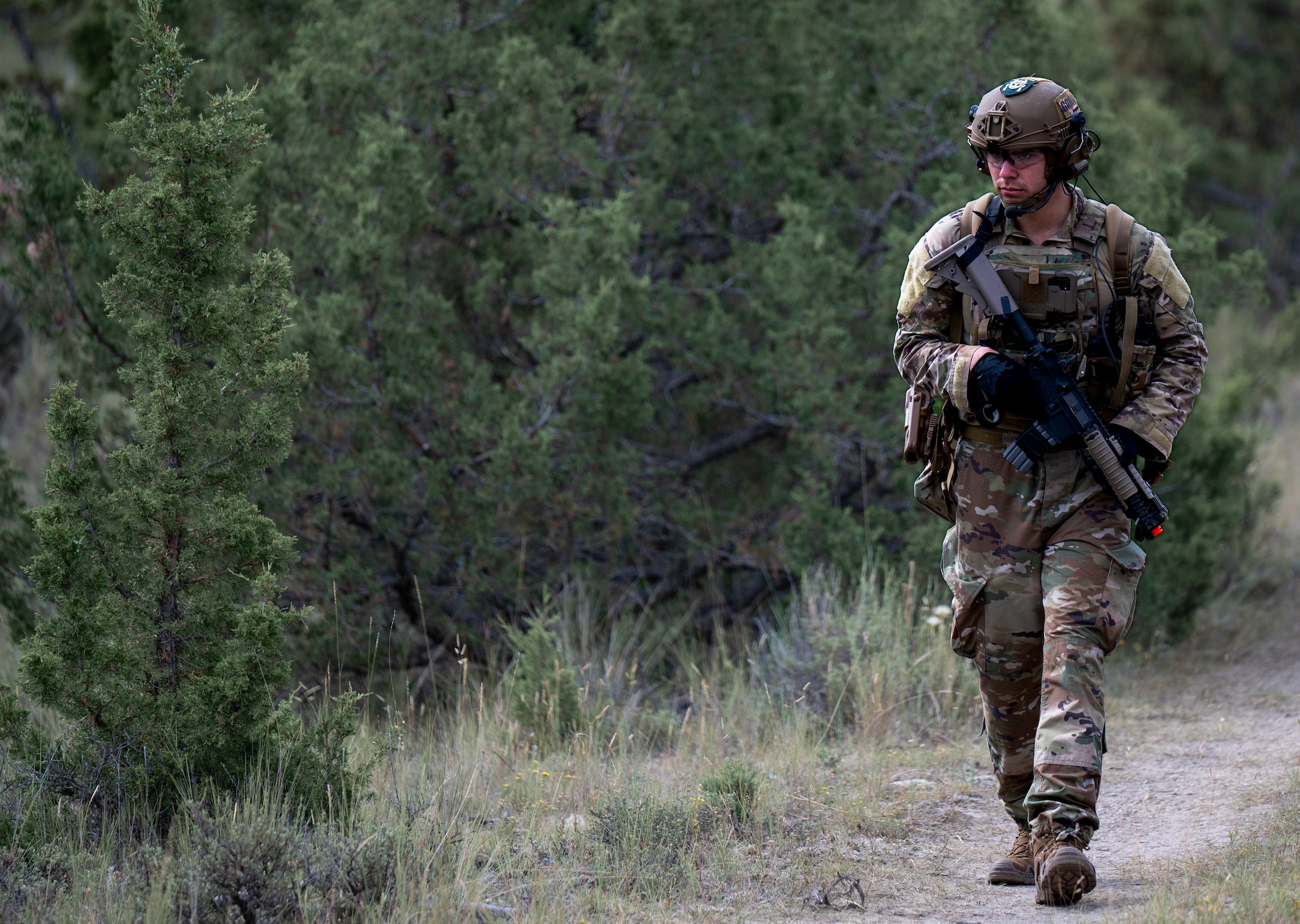 U.S. Air Force Airman 1st Class Jacob Miller-Lujan, 28th Civil Engineer Squadron explosive ordnance disposal (EOD) technician, conducts a dismounted patrol to the location of the next training task during an exercise at Limestone Hills Training Area, Montana, Aug. 18, 2026. Reaching an objective often requires EOD teams to move dismounted across varied terrain while maintaining security en-route to the hazard. (U.S. Air Force photo by Tech. Sgt. Aaron Thomasson)