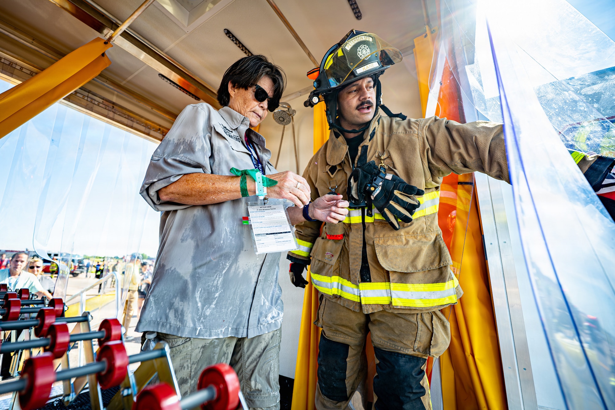 U.S. Air Force Senior Airman Dominique Kane, 21st Civil Engineer Squadron firefighter, assists an exercise participant portraying a simulated victim
