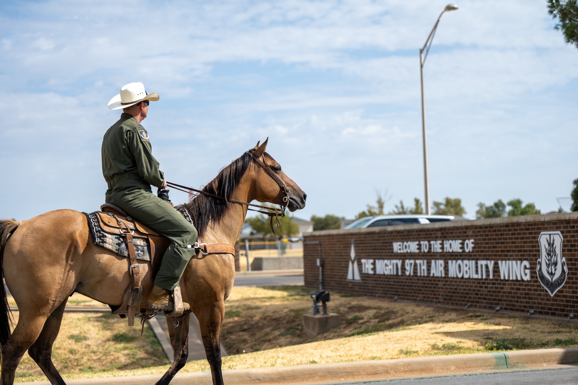 Col. Richard Kind, 97th Air Mobility Wing commander, rides a horse toward the main gate during the annual Cattle Drive at Altus Air Force Base, Oklahoma, Aug. 20, 2026. Kind joined other base leaders and community members in the event, which highlights the longstanding relationship between Altus AFB and the surrounding community. (U.S. Air Force photo by Airman 1st Class Nathan Langston)