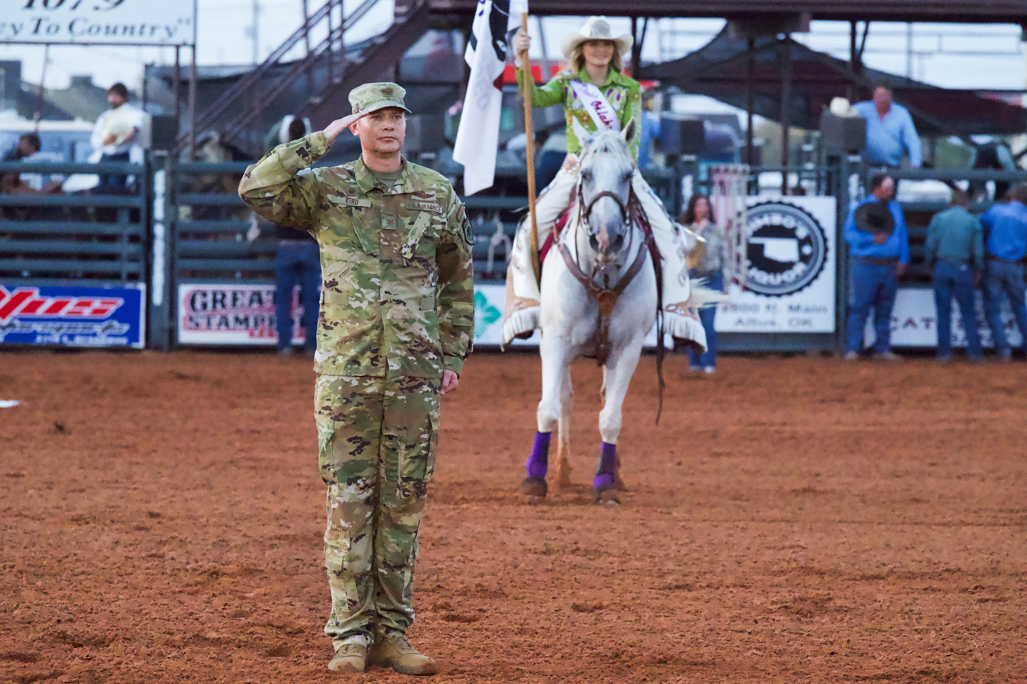 U.S. Air Force Col. Richard Kind, 97th Air Mobility Wing commander, salutes the U.S. flag during the National Anthem at the rodeo grounds in Altus, Oklahoma, Aug. 20, 2026. Military Appreciation Night held at the rodeo follows the annual Altus Air Force Base Cattle Drive. (U.S. Air Force photo by Airman Elijah Likowski)