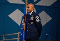 Chief Master Sgt. Israel Nunez, Air Force Reserve Command command chief, stands holding the guidon