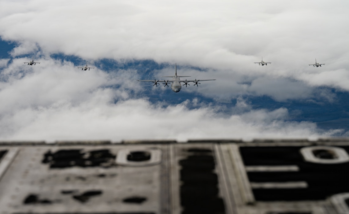 Four Belgian Air Force F-16 Fighting Falcon aircraft  fly in formation with a U.S. Air Force C-130J Super Hercules aircraft assigned to the 37th Airlift Squadron over Iceland during exercise Northern Viking 26