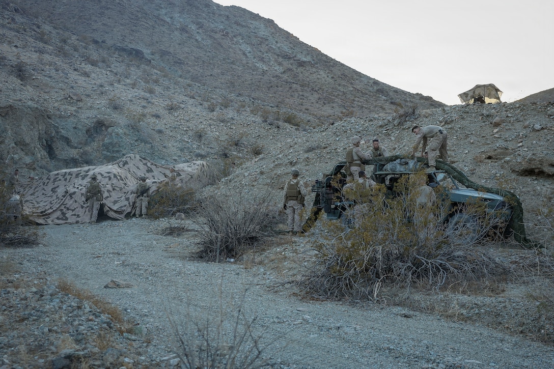 U.S. Marines with 2nd Marine Regiment, 2nd Marine Division, conceal tactical vehicles and a Menace-X during a test for forward capability as part of Service Level Training Exercise 4-26 on Marine Corps Air Ground Combat Center, Twentynine Palms, California, August 4, 2026. SLTE 4-26 is designed to be a challenging, realistic training environment that produces combat-ready forces capable of operating as an integrated Marine Air Ground Task Force across all domains of military operations. (U.S. Marine Corps photo by Staff Sgt. Matthew Kirk)