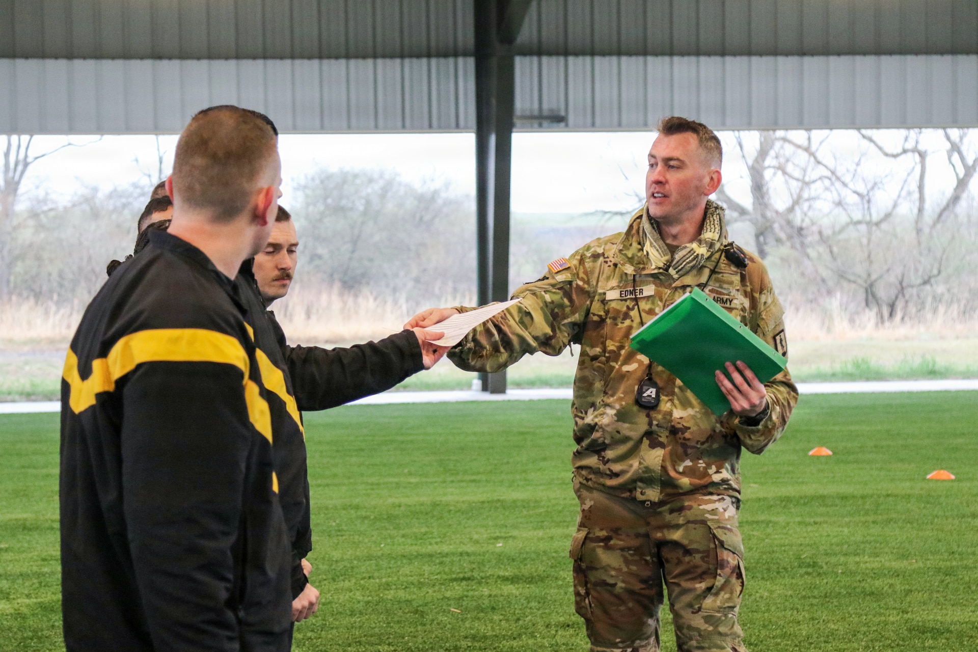 U.S. Army Staff Sgt. Timothy Edner (right), a Basic Leader Course senior facilitator with the 166th Regiment - Regional Training Institute, hands out physical fitness test scorecards to Soldiers prior to an Army fitness test Apr. 2, 2026 at Fort Indiantown Gap, Pa.  (U.S. Army National Guard photo by Sgt. 1st Class Shane Smith)