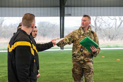 U.S. Army Staff Sgt. Timothy Edner (right), a Basic Leader Course senior facilitator with the 166th Regiment - Regional Training Institute, hands out physical fitness test scorecards to Soldiers prior to an Army fitness test Apr. 2, 2026 at Fort Indiantown Gap, Pa.  (U.S. Army National Guard photo by Sgt. 1st Class Shane Smith)