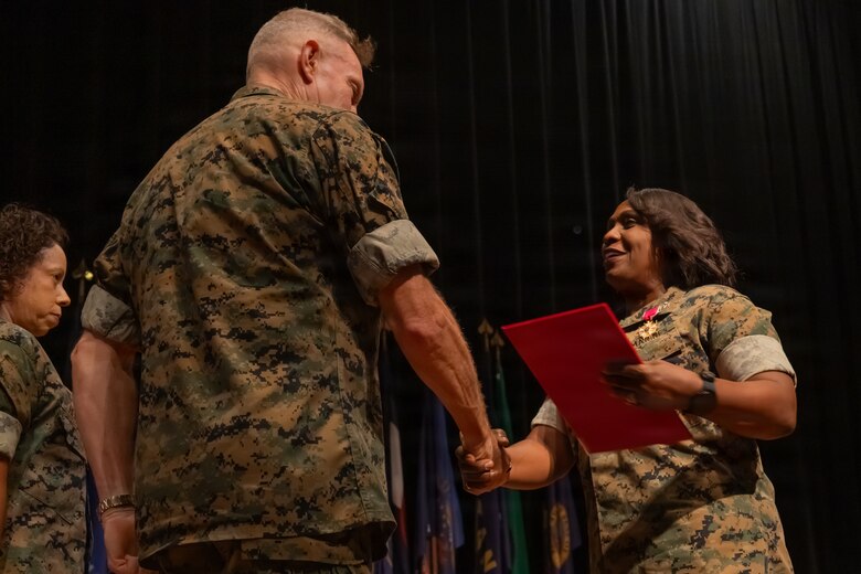 U.S. Marine Corps Col. Morina D. Foster, outgoing commanding officer of Wounded Warrior Regiment, shakes hands with Lt. Gen. William J. Bowers, deputy commandant for Manpower and Reserve Affairs, after being awarded the Legion of Merit during the WWR change of command ceremony held at Marine Corps University’s Warner Hall on Marine Corps Base Quantico, Virginia, July 15, 2026. The ceremony signifies the transfer of command from Foster to Col. Javier A. Garcia, the incoming commanding officer for WWR, and the continuation of the unit’s mission to serve recovering service members. (U.S. Marine Corps photo by Lance Cpl. Daniel Y. Ruizdelgado)
