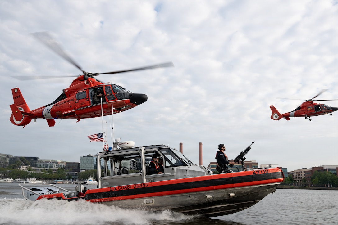 Two Coast Guard MH-65 Dolphin helicopters from Air Station Washington and a Coast Guard 29-foot Response Boat-Small (RB-S) from Station Washington conduct operational maneuvers during a capabilities demonstration on the Potomac River, Aug. 20, 2026. The evolution showcased the crews’ ability to integrate aviation and maritime assets in support of missions across the National Capital Region. (U.S. Coast Guard photo by PA3 Austin Canos)