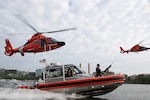 Two Coast Guard MH-65 Dolphin helicopters from Air Station Washington and a Coast Guard 29-foot Response Boat-Small (RB-S) from Station Washington conduct operational maneuvers during a capabilities demonstration on the Potomac River, Aug. 20, 2026. The evolution showcased the crews’ ability to integrate aviation and maritime assets in support of missions across the National Capital Region. (U.S. Coast Guard photo by PA3 Austin Canos)