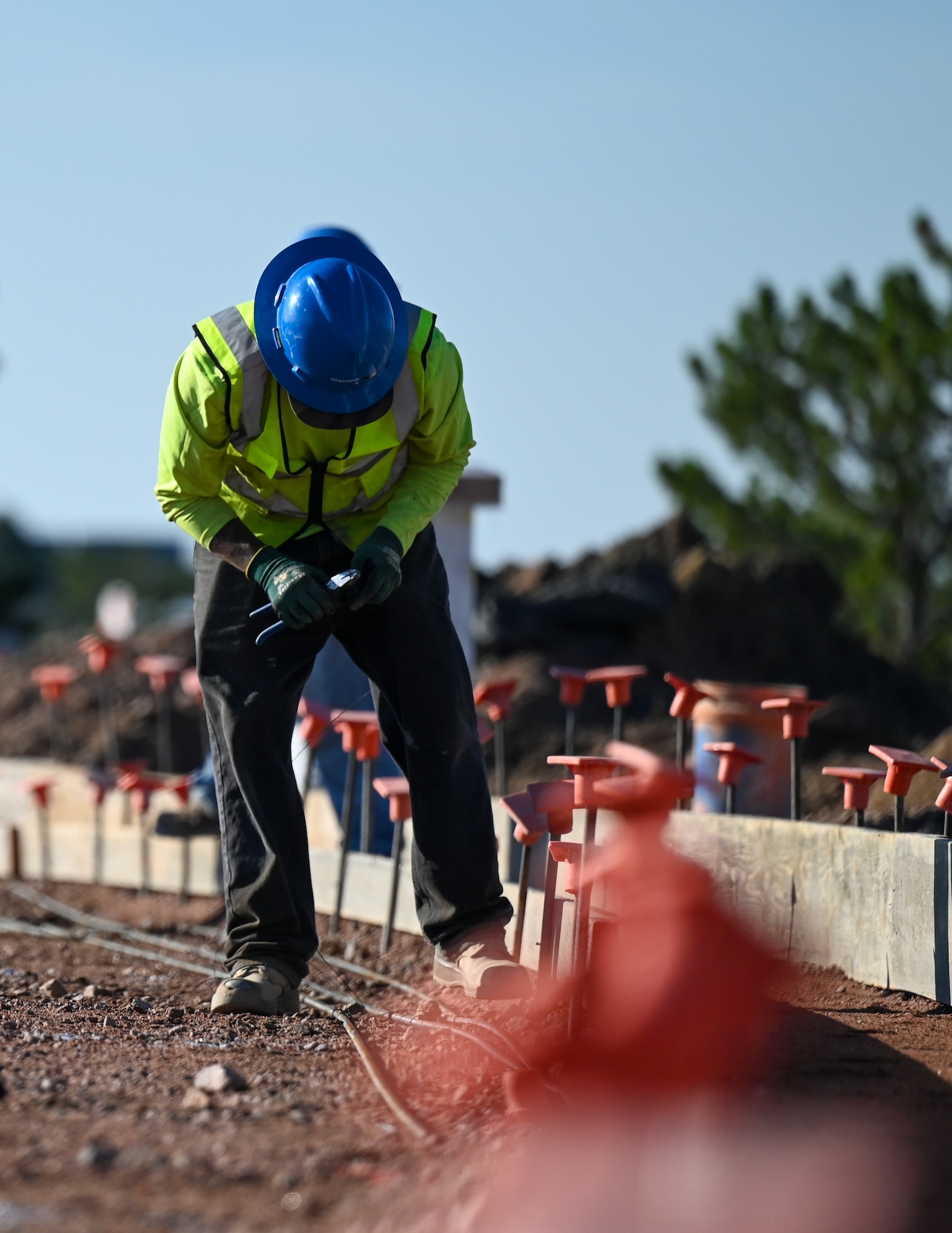 A construction worker wires piping together during the Enoch Gate road construction on Schriever Space Force Base.