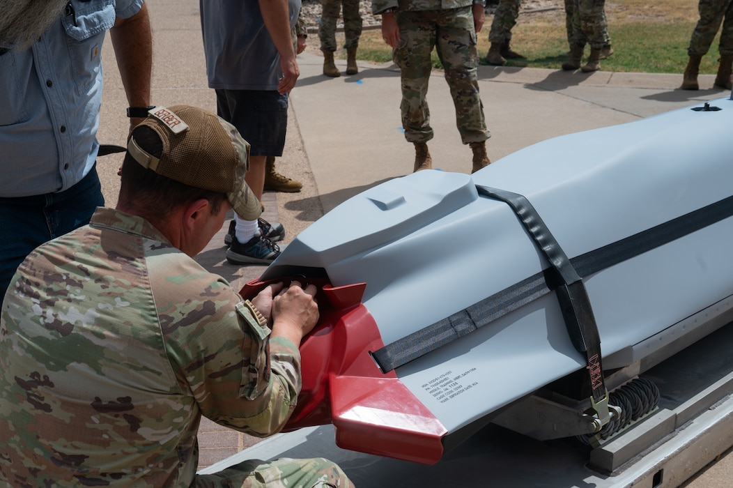 U.S. Air Force Col. Jason Gerber, 17th Training Group commander, removes a tag from a Dummy Air Training Munition 158A missile during its delivery to the 315th Training Squadron at Goodfellow Air Force Base, Texas, Aug. 19, 2026. The DATM-158A will help intelligence, surveillance and reconnaissance professionals connect academic instruction to operational settings. (U.S. Air Force photo by Senior Airman Brian Lummus)