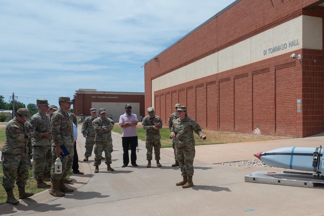 U.S. Air Force Lt. Col. Stephanie Taylor, 315th Training Squadron commander, discusses the educational benefits of a Dummy Air Training Munition 158A missile during its delivery to the 315th TRS at Goodfellow Air Force Base, Texas, Aug. 19, 2026. Instructors will use the DATM-158A to reinforce weapons familiarization, weapon-target pairing concepts, mission planning considerations and the relationship between intelligence analysis and kinetic effects. (U.S. Air Force photo by Senior Airman Brian Lummus)