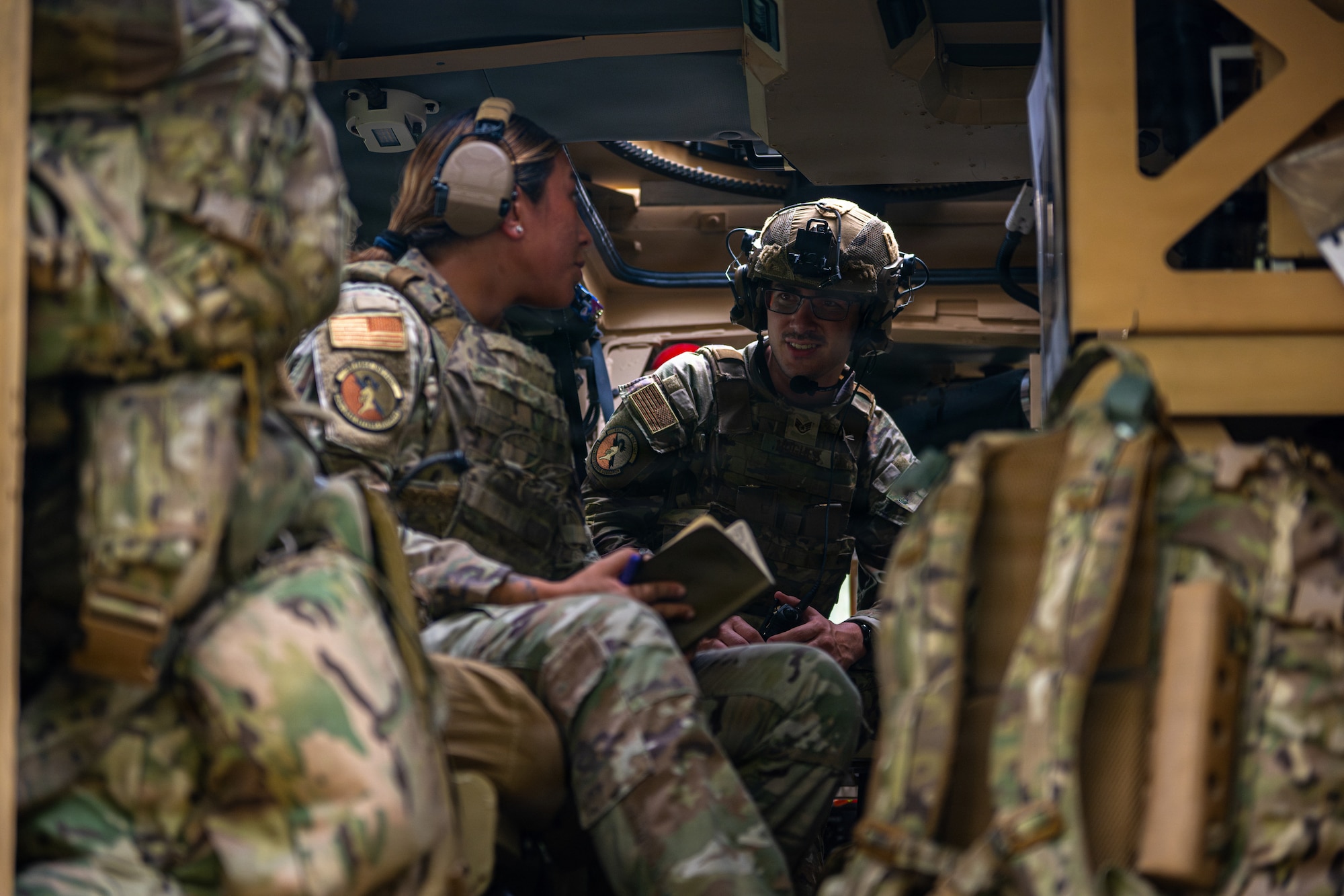 Airmen in a military vehicle.