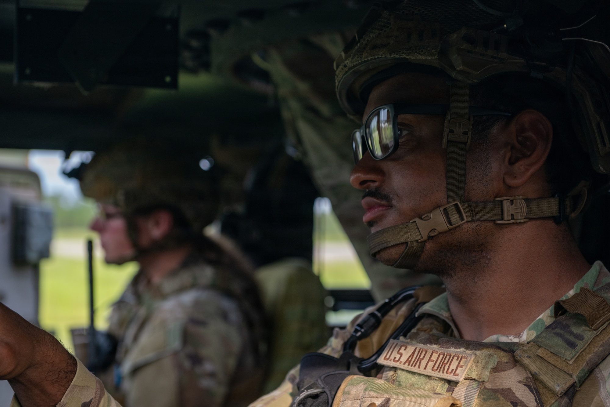 Airmen in a military vehicle.