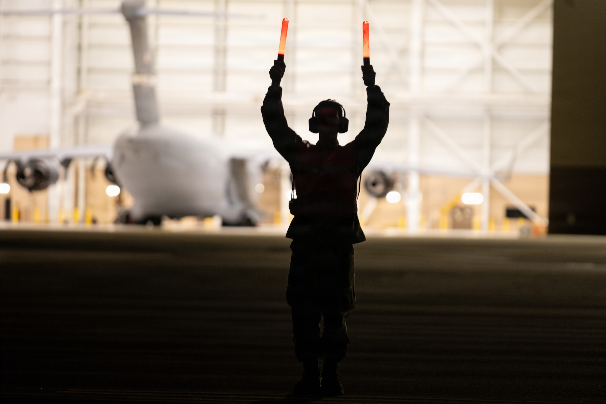 Airman marshaling a plane