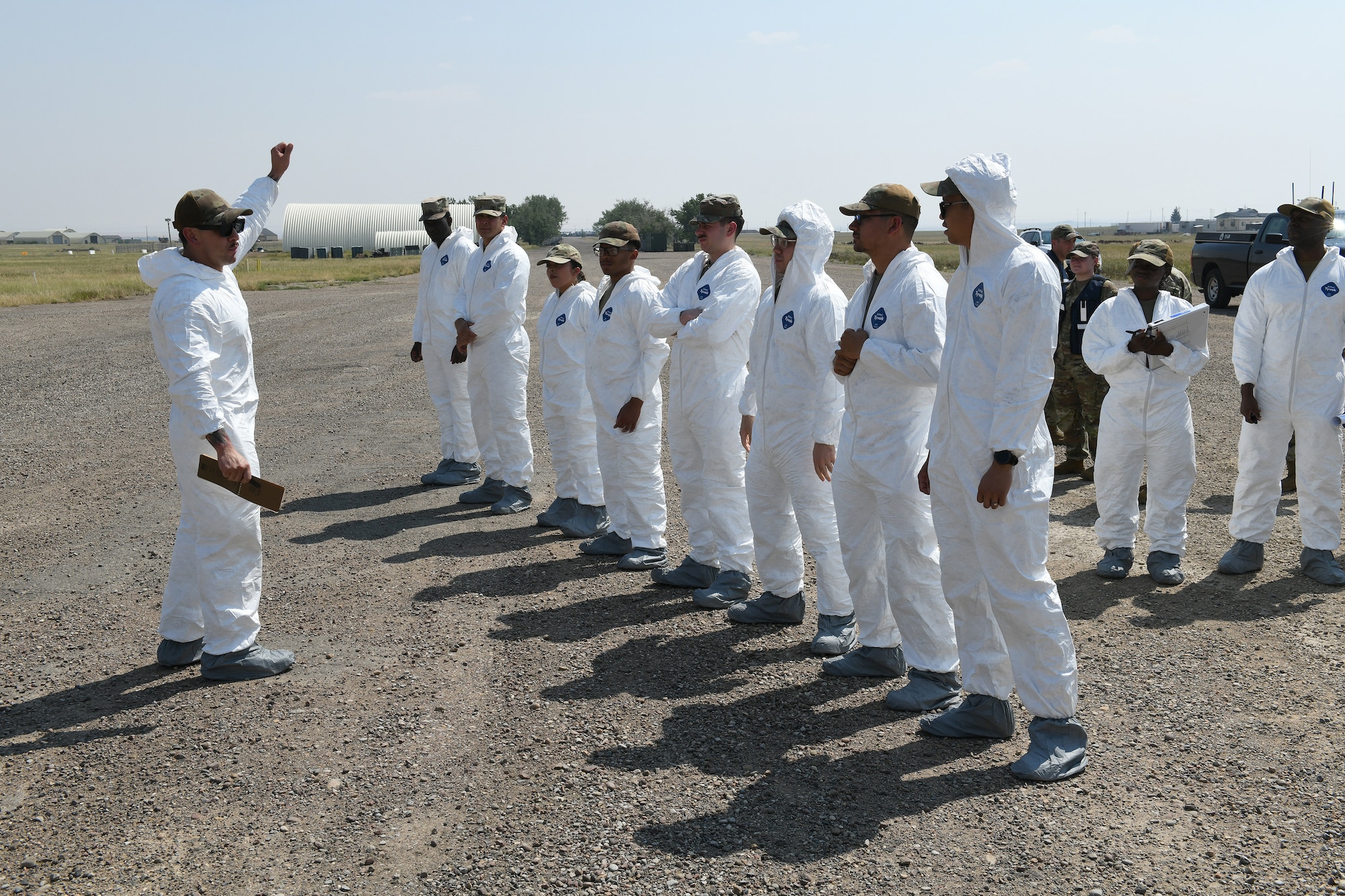 U.S. Air Force members in white safety suits prepare for search and recovery procedures during a Mass Accident Response Exercise on Malmstrom AFB.