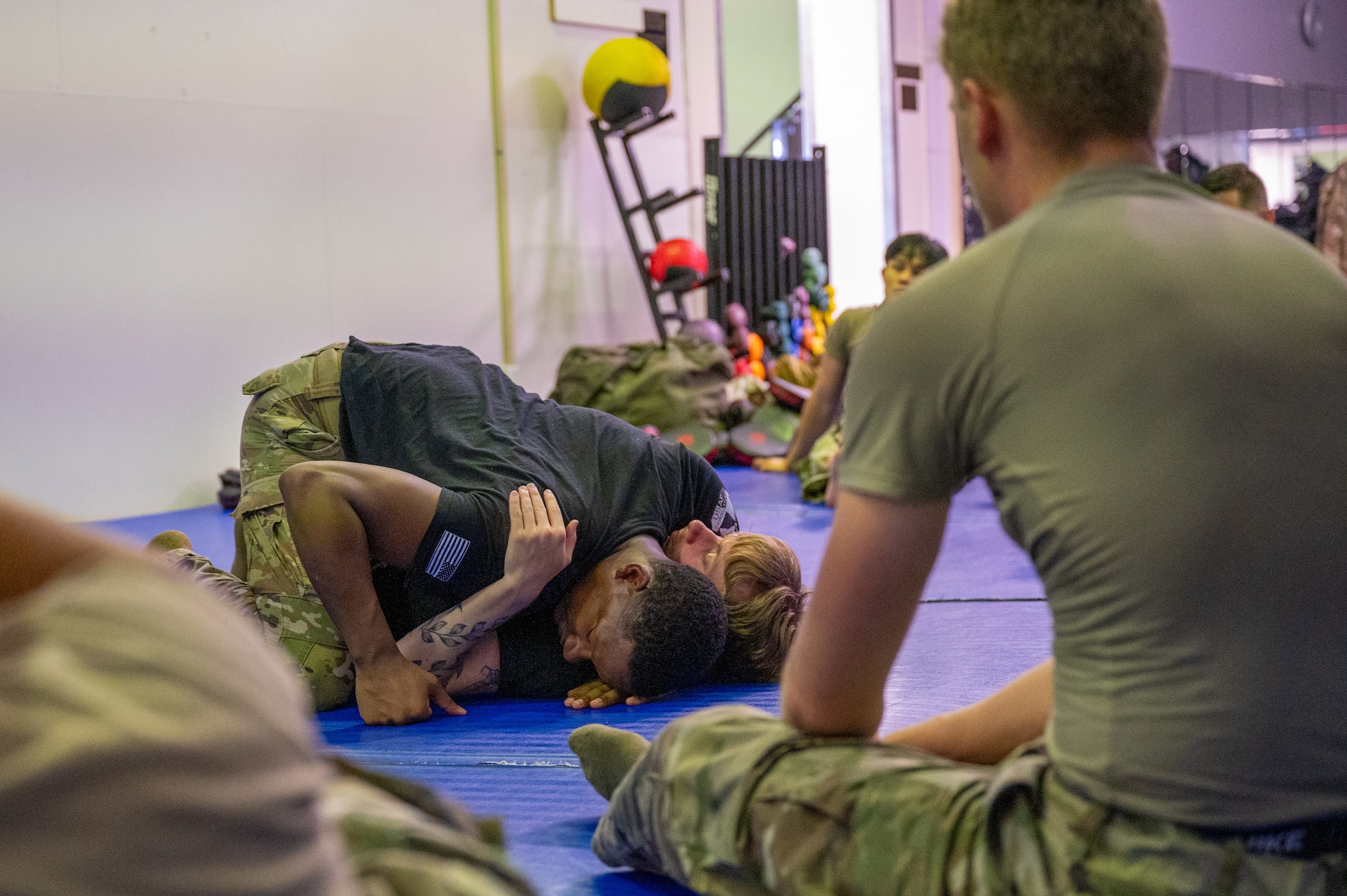 Airmen grapple on the floor during a combatives training.