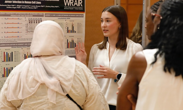 SILVER SPRING, Md. (Aug. 13, 2026) Peri Nelson, an intern with Naval Medical Research Command’s (NMRC) summer program, presents research to command staff during a STEM expo. NMRC, headquarters of Navy Medicine Research & Development, is engaged in a broad spectrum of activity from basic science in the laboratory to field studies in austere and remote areas of the world to investigations in operational environments. In support of Navy, Marine Corps and joint U.S. warfighter health, readiness and lethality, researchers study infectious diseases, biological warfare detection and defense, combat casualty care, environmental health concerns, aerospace and undersea medicine, operational mission support and epidemiology. Navy Medicine’s 44,000+ talented and ready forces optimize health readiness, deliver quality healthcare, and provide global expeditionary medical support to warfighters. (U.S. Navy photo by Sidney Hinds/ Released)
