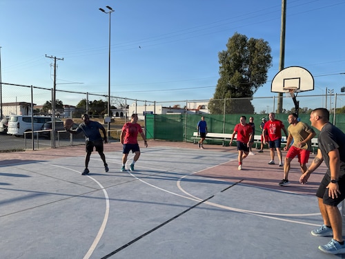 A group of people play basketball.