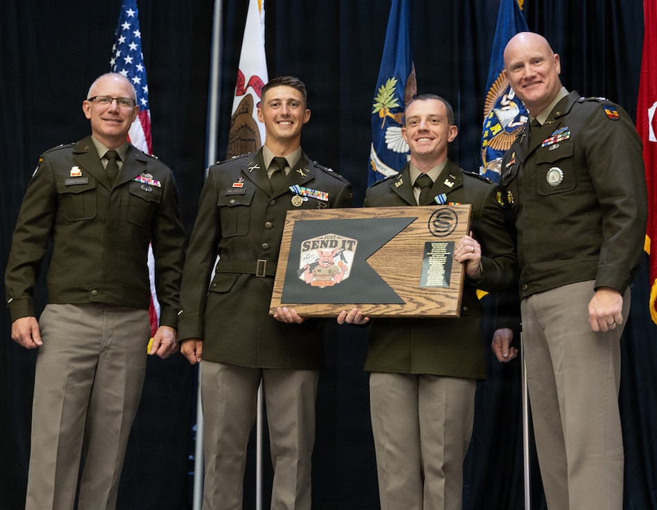 2nd Lt. Sean Wilhour, second from left, and 2nd Lt. Joseph Fisher, second from right, present a gift from Officer Candidate School Class 71-26 to Brig. Gen. Michael Eastridge, left, Deputy Assistant Adjutant General, Illinois Army National Guard, and Col. Paul Metzdorff, Commander, 129th Regiment.