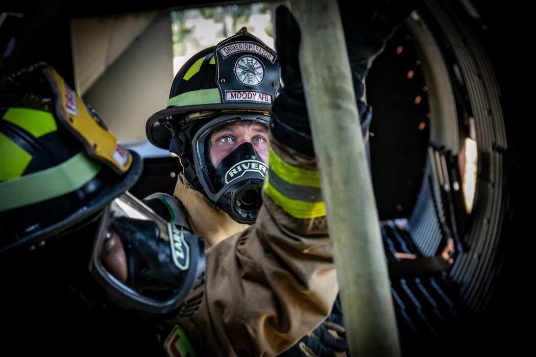 firefighters move a fire hose during a routine training