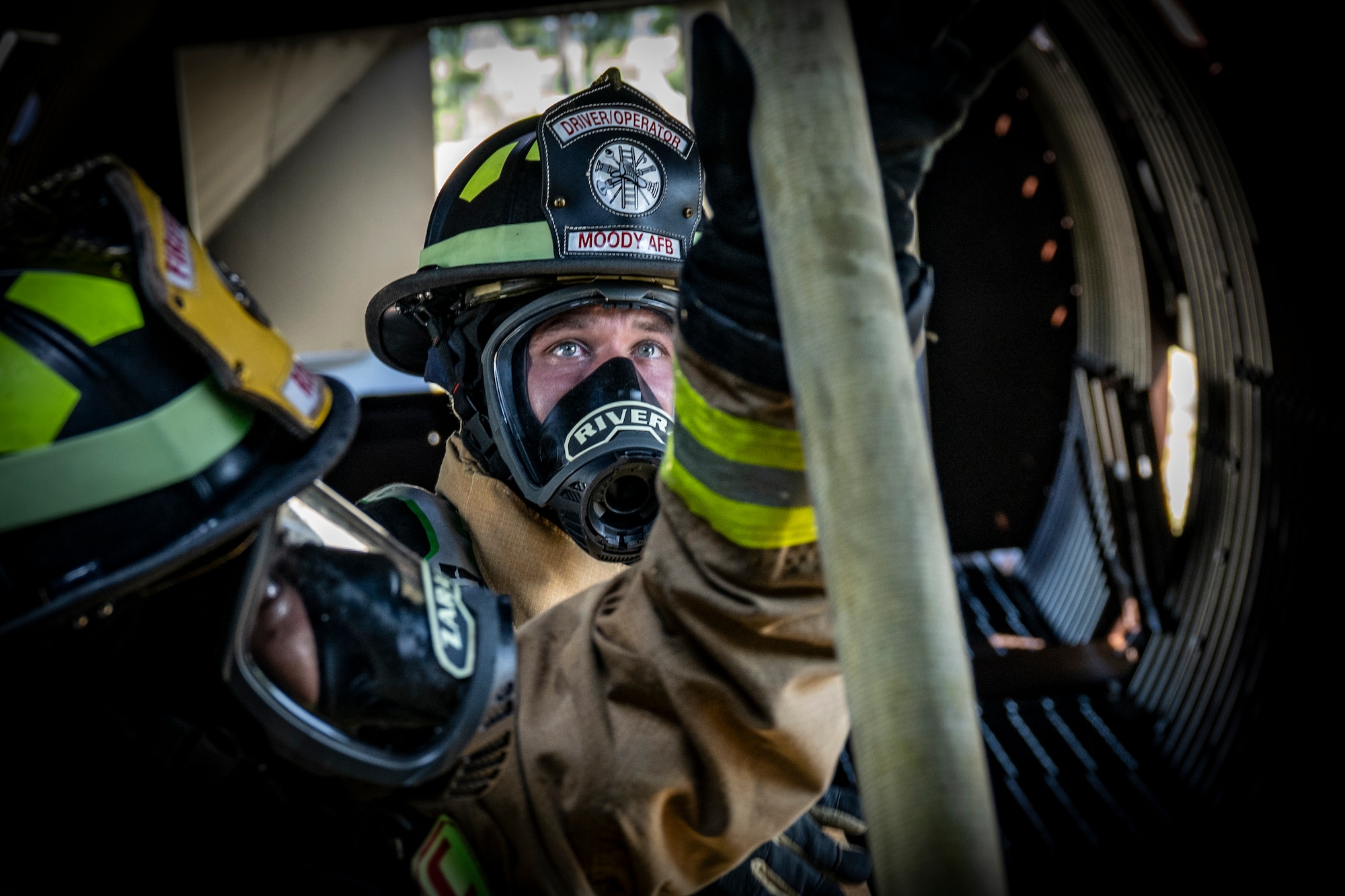 firefighters move a fire hose during a routine training