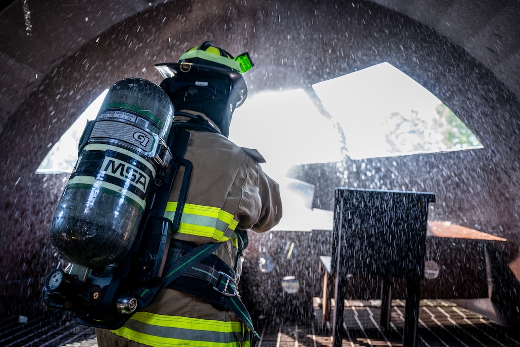 firefighter operates a fire hose during a routine training