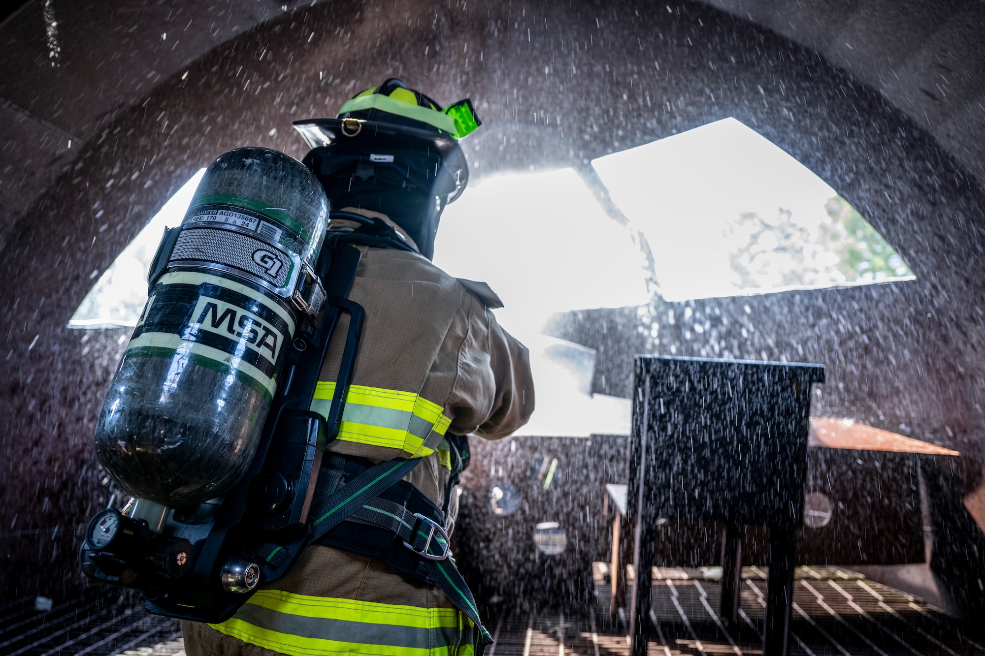 firefighter operates a fire hose during a routine training