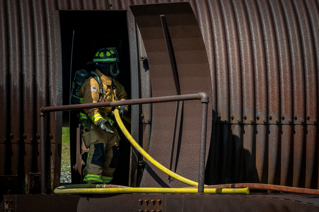 firefighter maneuvers a fire hose