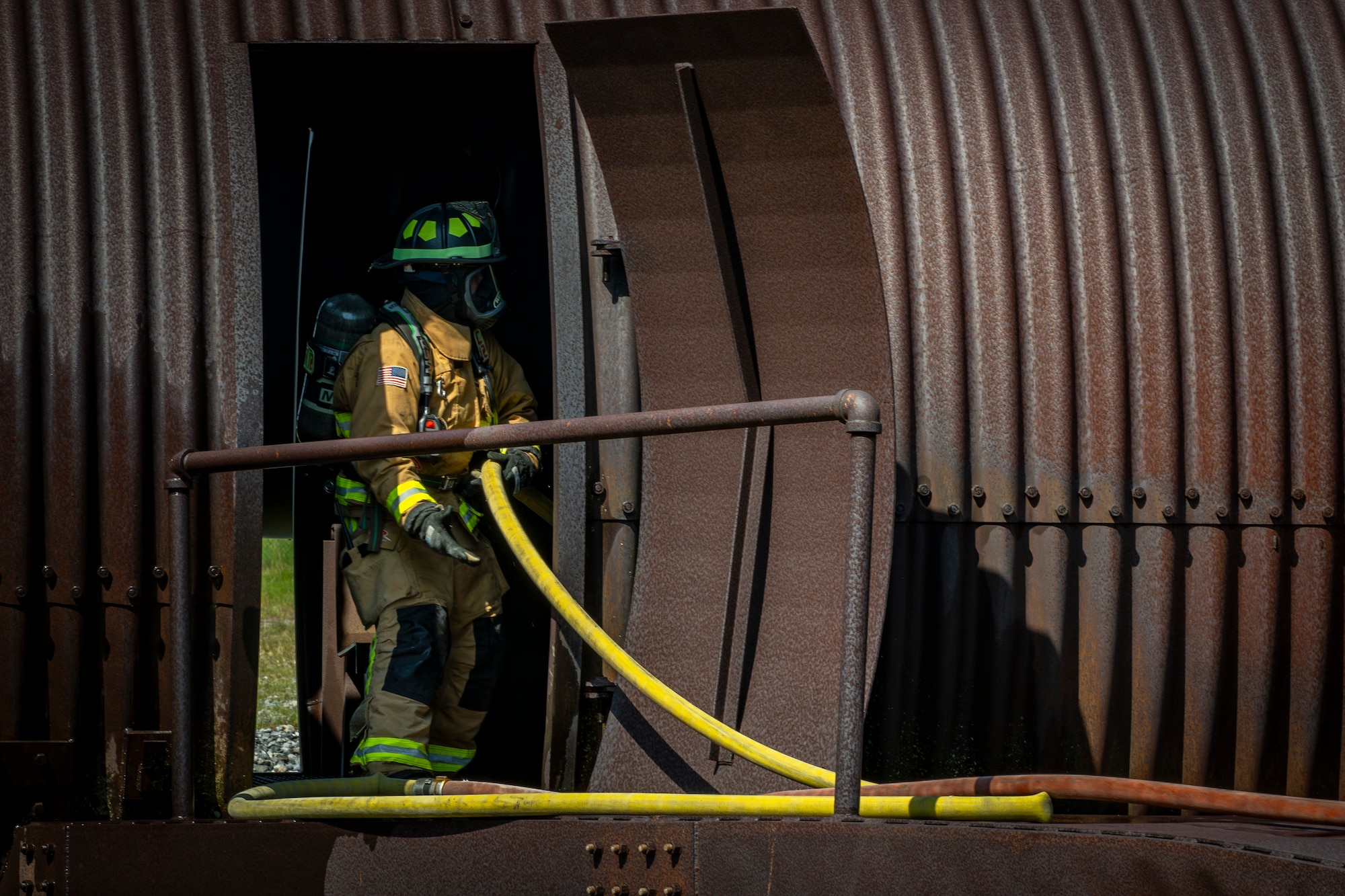 firefighter maneuvers a fire hose