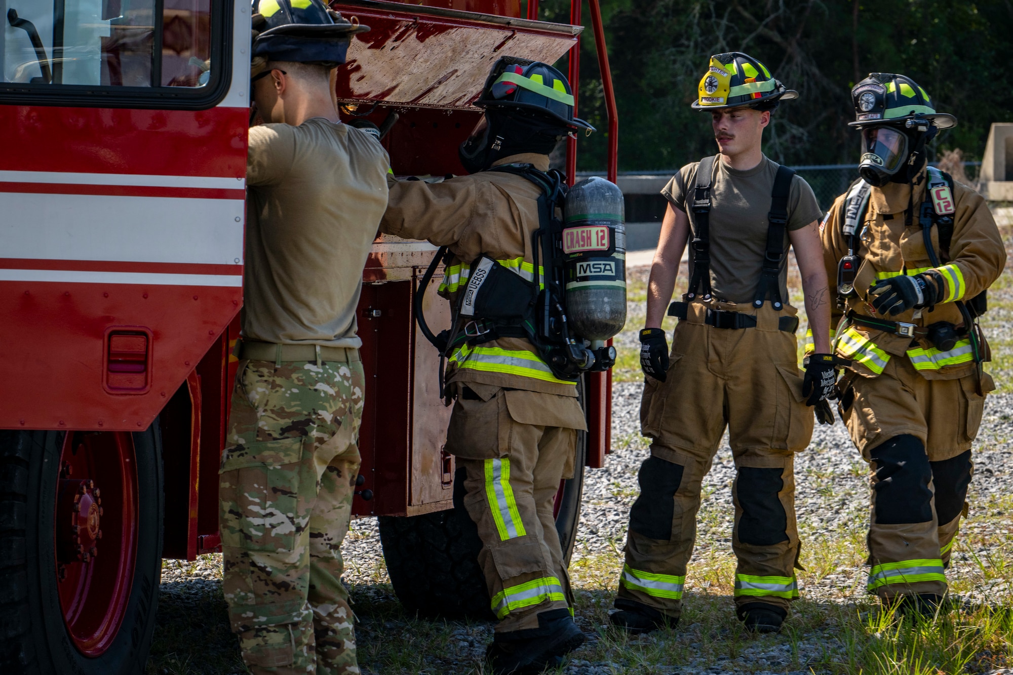 Air Force firefighters standing by fire truck