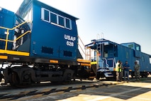 A photo of four people conversing in front of a locomotive.
