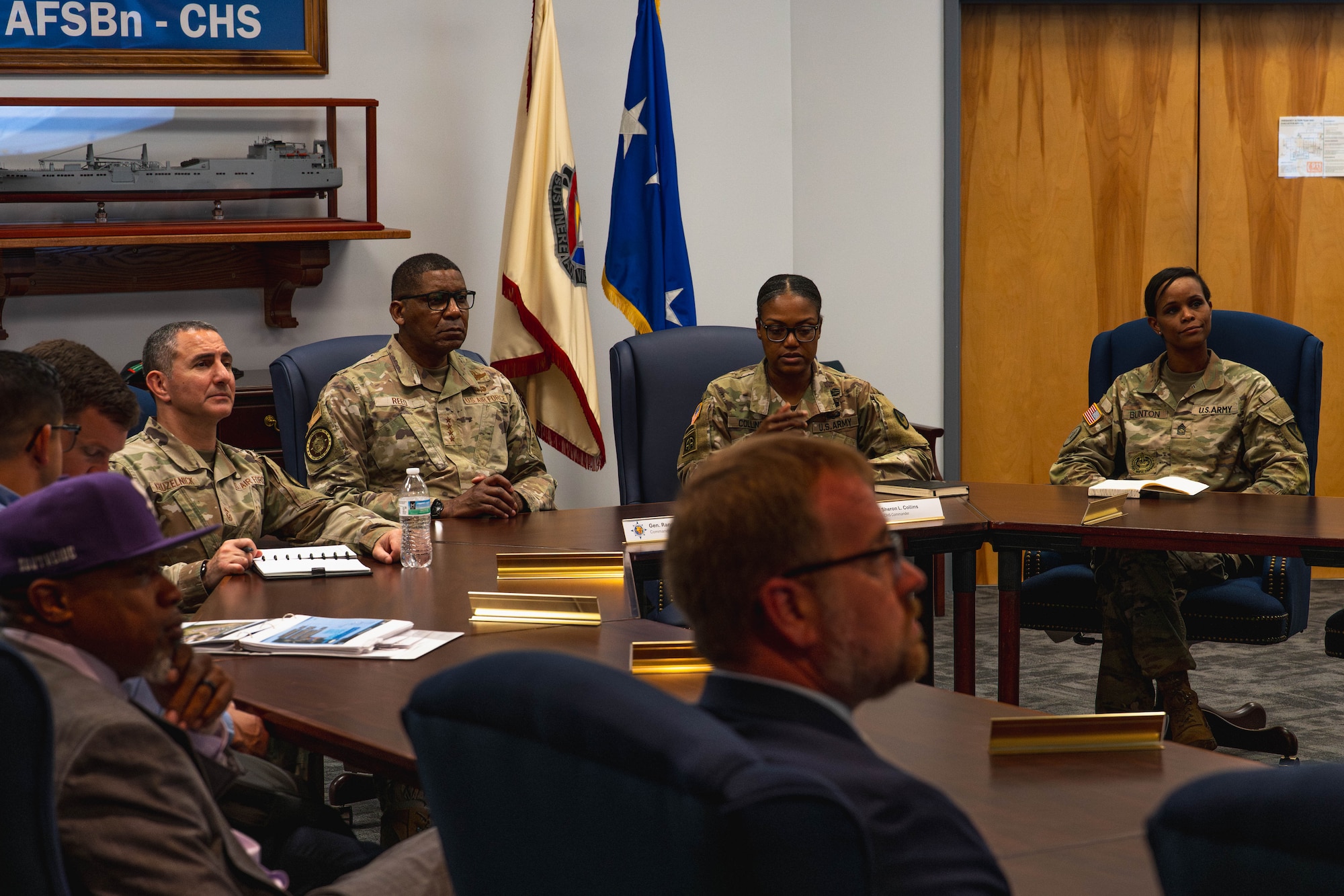 A photo of people in a roof listening to a briefing.