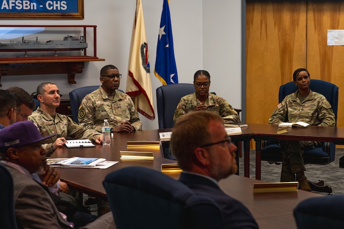 A photo of people in a roof listening to a briefing.