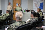 Cmdr. Carmen Davis, evaluator, Navy Reserve-Naval Medical Forces Development Command, speaks to Sailors selected to serve as fleet subject matter experts for the first-of-its-kind Operational Readiness Evaluation (ORE) of an Expeditionary Medical Unit (EMU), and first ever afloat ORE for an EMU, July 24, 2026. (U.S. Navy photo by Petty Officer 1st Class Shayla Hamilton)