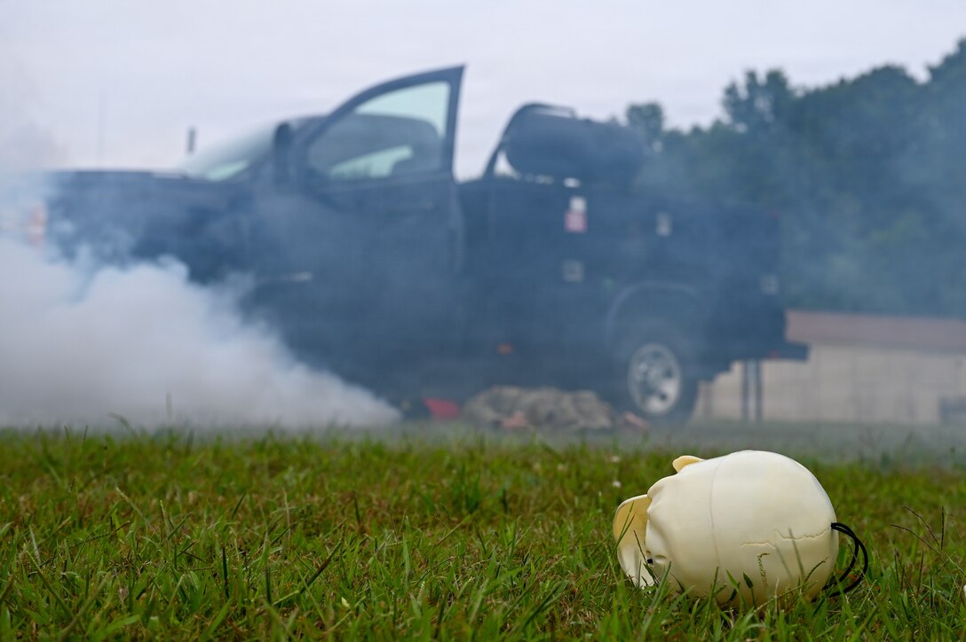 A simulated skull rests on the ground besides a simulated exploded vehicle during a Combat Readiness Exercise at Westover Air Reserve Base, Chicopee, Mass., Aug. 23, 2026. Military training exercises are designed to truly showcase the brutality and necessary readiness associated with going to war. (U.S. Air National Guard photo by Airman 1st Class Elijah Harris)
