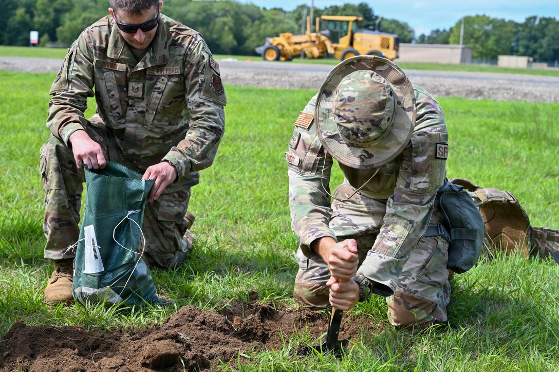 U.S. Air Force Tech. Sgt. Bailey Canedy, a defender with the 104th Security Forces Squadron, digs a defensive fighting position during a Combat Readiness Exercise at Westover Air Reserve Base, Chicopee, Mass., Aug. 23, 2026. Defensive fighting positions, or DFPs, are set around the perimeters of forward operating bases and are manned 24/7 to maintain the maximum possible defensive posture against attacks. (U.S. Air National Guard photo by Airman 1st Class Elijah Harris)
