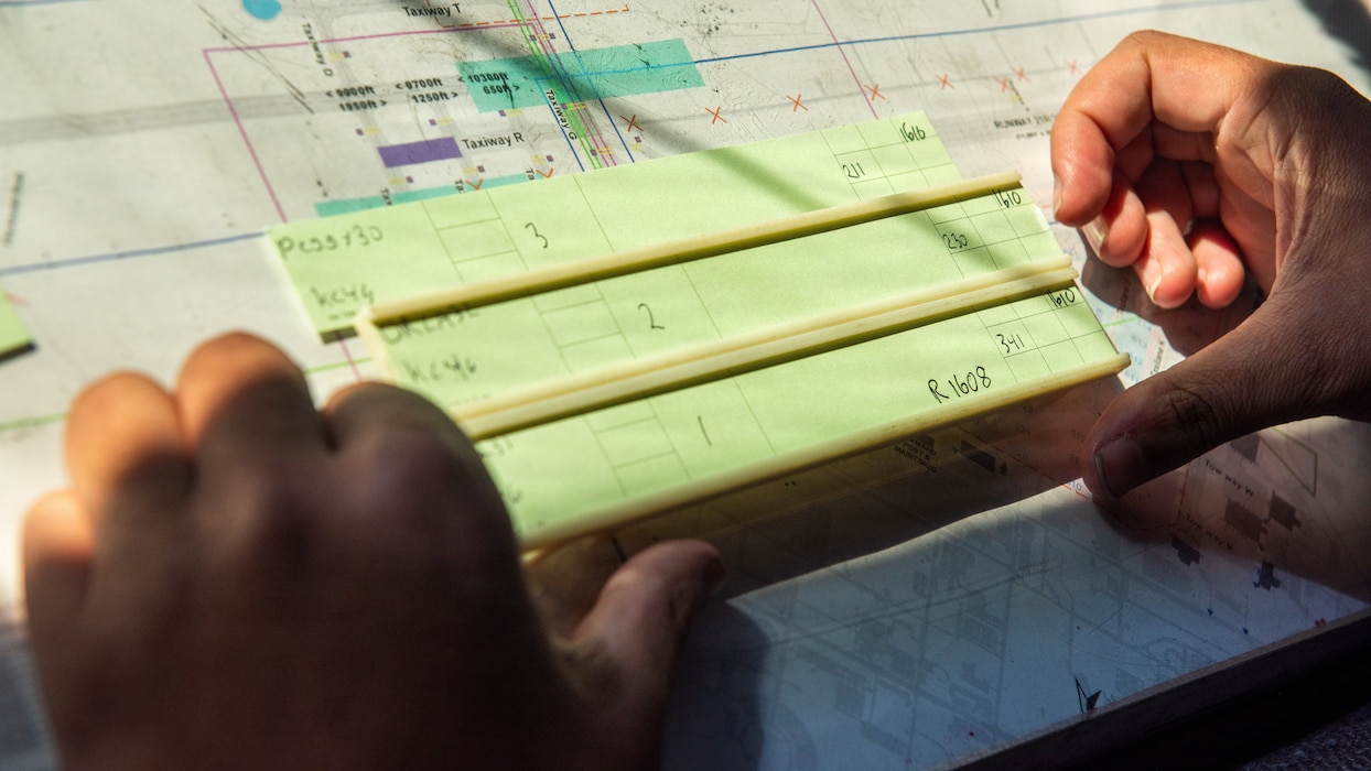 Airman organizing flight progress strips