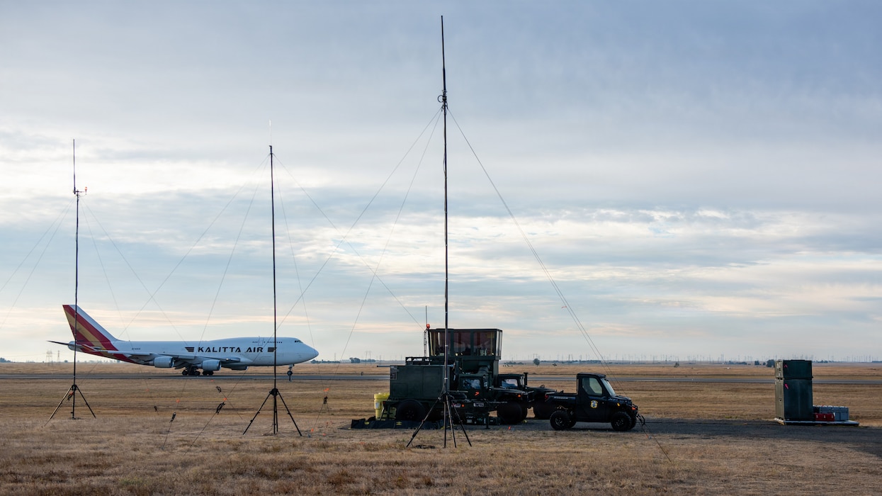 Commercial aircraft taxiing past mobile control tower