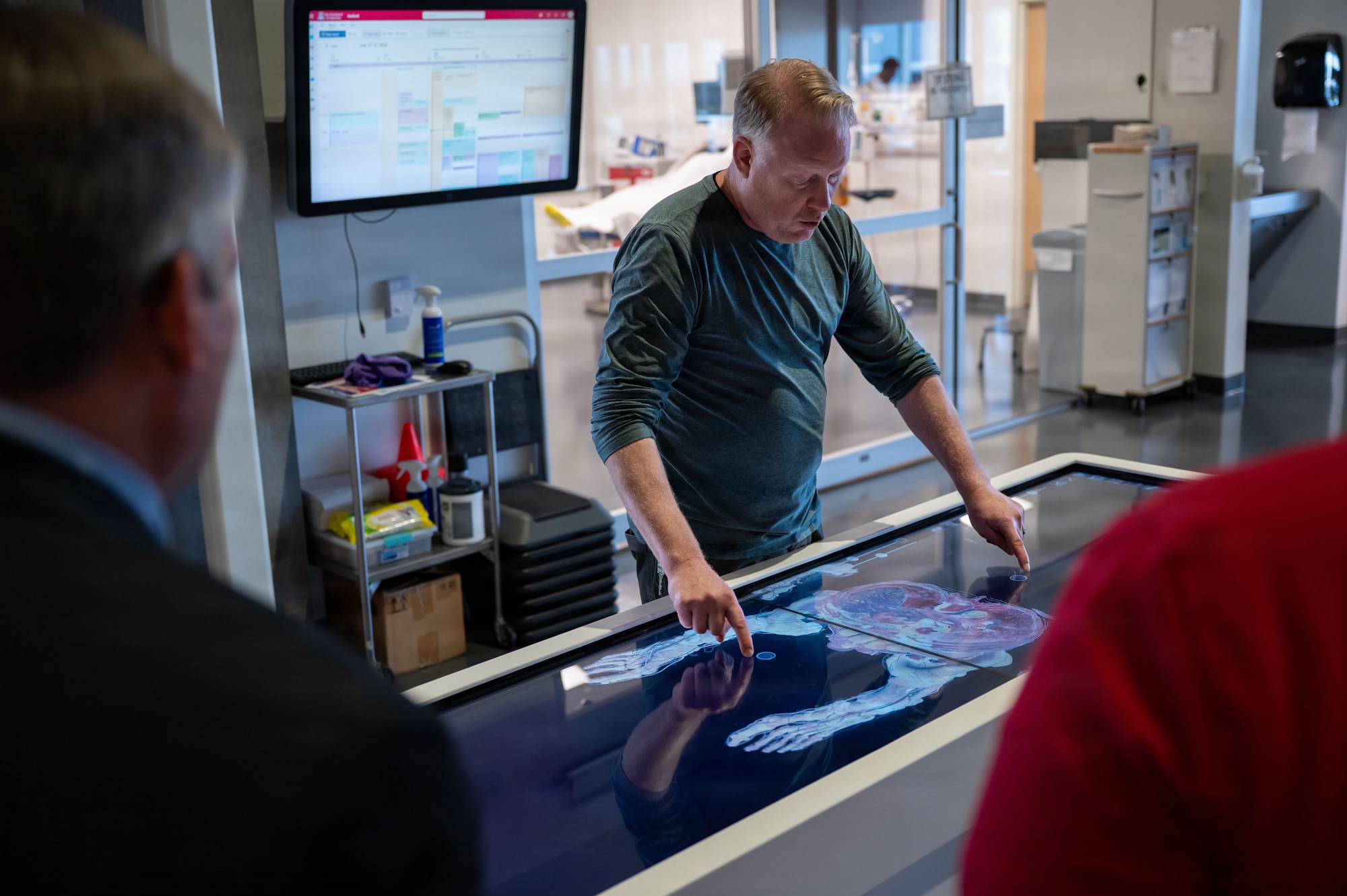 Dave Biffar, University of Arizona (UofA) Healthcare Simulation Operations director, shows Davis-Monthan Air Force Base personnel and local community partners how the Anatomage Table in UofA’s Arizona Simulation Technology and Education Center aids in medical learning and skill application at Tucson, Arizona, July 29, 2026. The Anatomage Table is an interactive system that allows individuals to conduct in-depth examinations on a simulated cadaver. (U.S. Air Force photo by Senior Airman Jasmyne Bridgers-Matos)