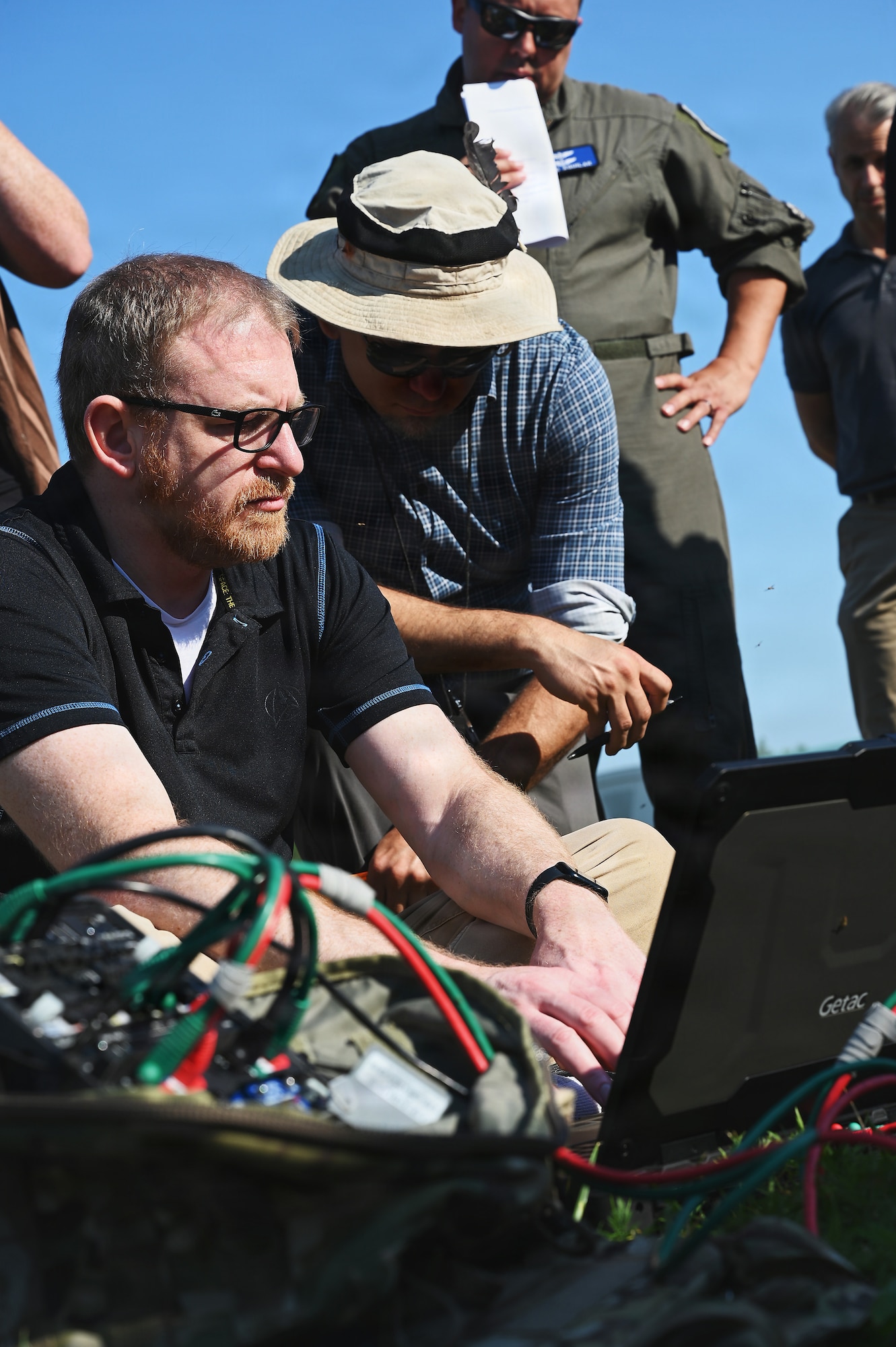 Members of the Air Force and Ohio Air National Guard look at laptops during field prototype testing evaluation for the Collaborative Combat Aircraft (CCA) Portable Command and Control Enclave (C2E).

(U.S. Air National Guard photo by Shane Hughes).