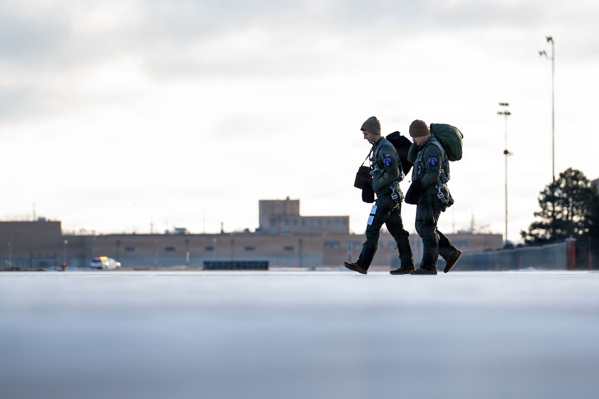 Capt. Jordan Glover, left, and Maj. Brian Leber, F-16 Fighting Falcon pilots assigned to the 175th Fighter Squadron, South Dakota Air National Guard, walk across the flight line at Joe Foss Field, South Dakota, Jan. 10, 2026.