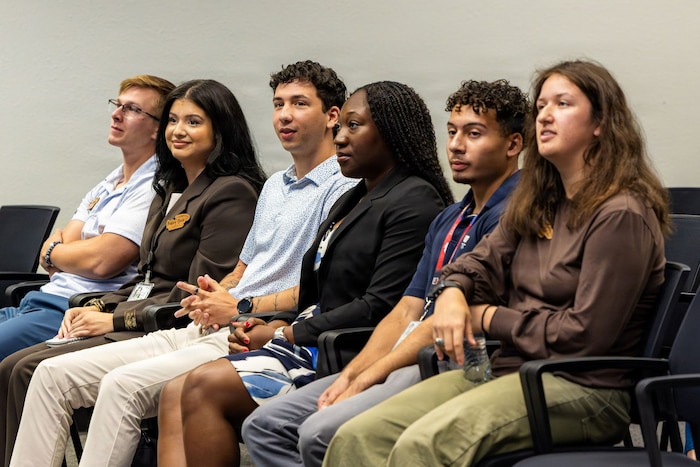 Ryan Soroka, Mallory Sorola, Connor English, Ciara Laird, Rodrick Benson and Ana Lemler, Virtual Institutes for Cyber and Electromagnetic Spectrum Research and Officer Training interns, watches Alejandro Cardona (not pictured) deliver his culmination presentation following a 10-week program at Edwards Air Force Base, California, Aug. 7, 2026. The Department of War VICEROY initiative cultivates cyber-spectrum leadership by funding student travel to military research centers, removing geographic barriers to defense careers. During the inaugural cohort at Edwards, eight interns supported active aerospace and cyber test programs. (U.S. Air Force photo by Ariana Ortega)