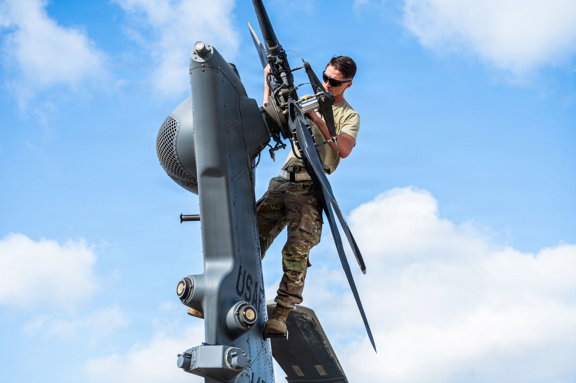 U.S. Air Force Senior Airman Isaiah Vargas, 55th Rescue Generation Squadron crew chief, inspects the tail rotor of an HH-60W Jolly Green II helicopter following the 55th Rescue Squadron’s arrival for Exercise Bamboo Eagle 26-1 at San Diego, California, Feb. 13, 2026. The exercise challenges Airmen to generate combat airpower and sustain operations in contested environments, showcasing the agility and resilience required to dominate modern battlefields. (U.S. Air Force photo by Senior Airman Jasmyne Bridgers-Matos)