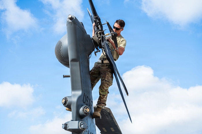 U.S. Air Force Senior Airman Isaiah Vargas, 55th Rescue Generation Squadron crew chief, inspects the tail rotor of an HH-60W Jolly Green II helicopter following the 55th Rescue Squadron’s arrival for Exercise Bamboo Eagle 26-1 at San Diego, California, Feb. 13, 2026. The exercise challenges Airmen to generate combat airpower and sustain operations in contested environments, showcasing the agility and resilience required to dominate modern battlefields. (U.S. Air Force photo by Senior Airman Jasmyne Bridgers-Matos)