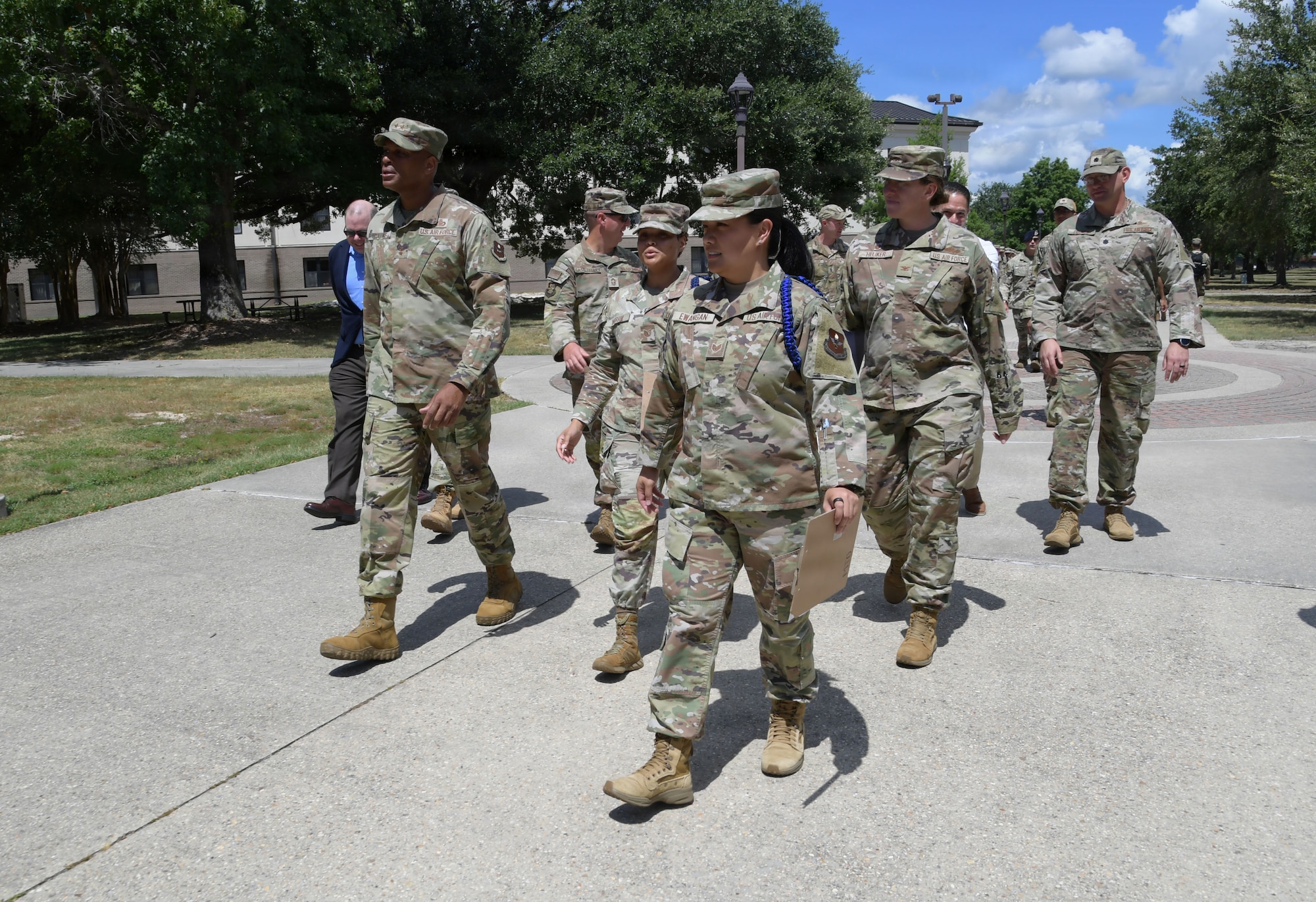 People wearing a U.S. Air Force uniforms walk on a walkway.