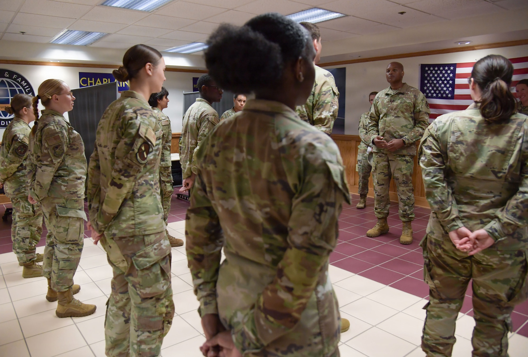 A man wearing a U.S. Air Force uniform speaks to a group of Airmen.