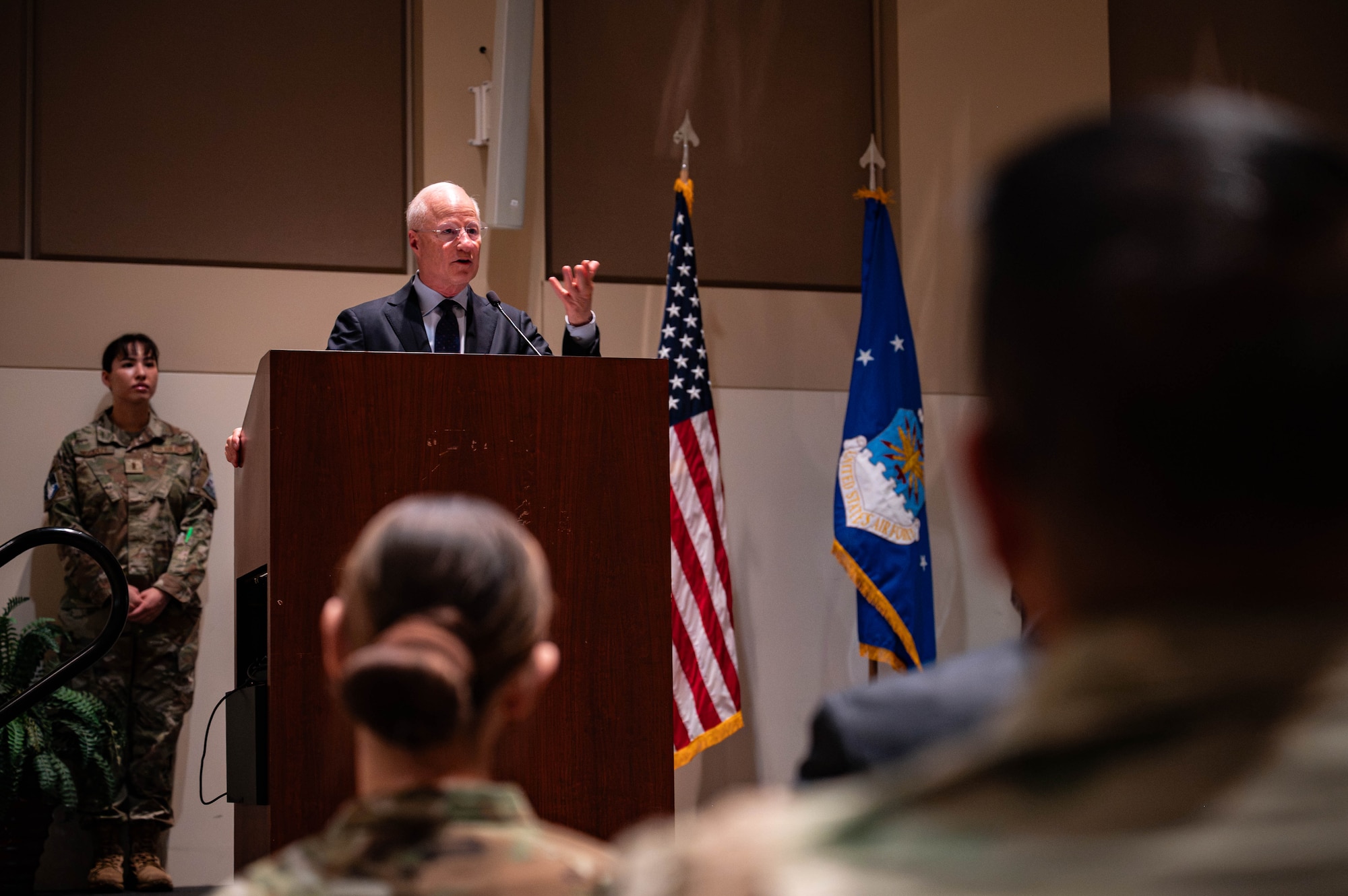 a in a suit stands at a podium in front of an audience