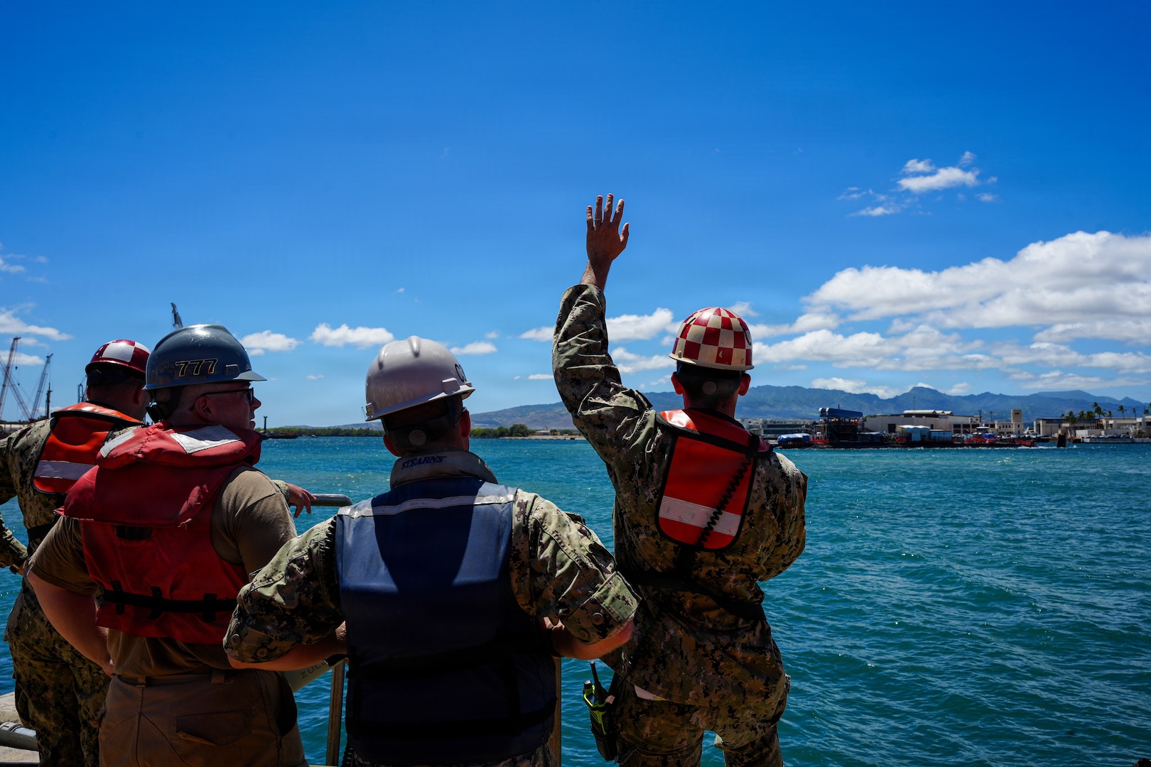 U.S. Navy Sailors serving as docking officers at Pearl Harbor Naval Shipyard and Intermediate Maintenance Facility (PHNSY & IMF) communicate with the crew of the Virginia-class fast-attack submarine USS North Carolina (SSN 777) via radio during an undocking evolution in Pearl Harbor, Hawaii, Aug. 12, 2026.
