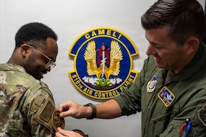 U.S. Air Force Col. Matthew T. Hoyt, 35th Fighter Wing deputy commander, right, presents a commander’s patch to Senior Airman Xavier Tanner, 610th Air Control Flight (ACF) weapons director, during a Wild Weasel Walk-Through at Misawa Air Base, Japan, Aug. 24, 2026.